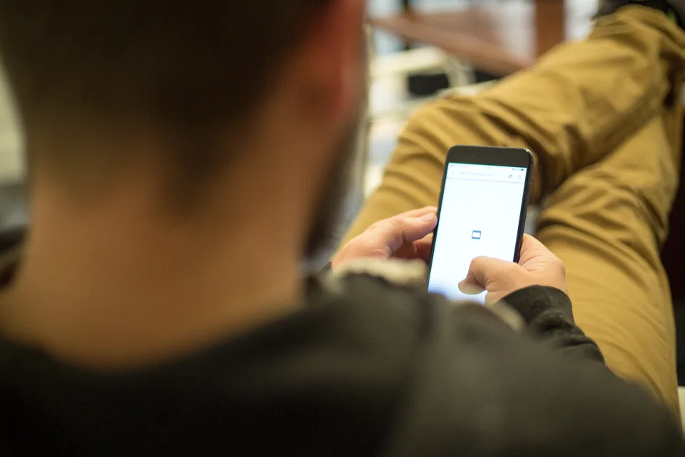 Persona revisando mensajes en su teléfono